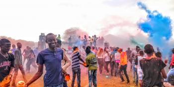 Young people in Loitokitok, Kenya throw pots of brightly-coloured powdered paint as part of the ICS-organised ‘Colourfest’