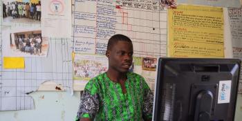 Volunteer Sylvester Ochieng works at his computer inside the office of disability rights organisation Slusuwe CBO in Webuye, Bungoma County