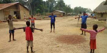 Volunteers teaching a group of children about social distancing