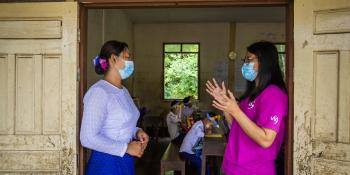 Volunteer and headteacher speak at a school in Mon state, Myanmar