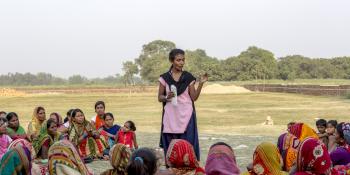 A 'Big Sister' demonstrates how to make sanitary towels to a group of women