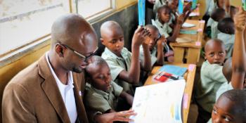 Papa Diouf reading to primary school pupils