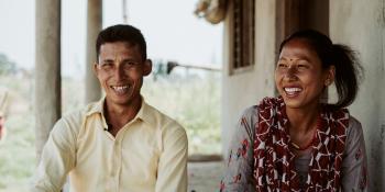 Couple smiling at camera.