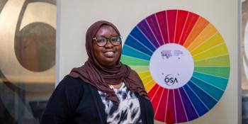 Youth group director in front of SDG poster