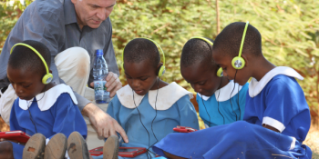 Andrew Ashe with children using tablets to support education in Malawi