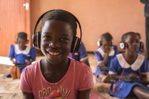 A student on the Unlocking Talent programme smiles as she works on her tablet in Mdzobwe Primary School