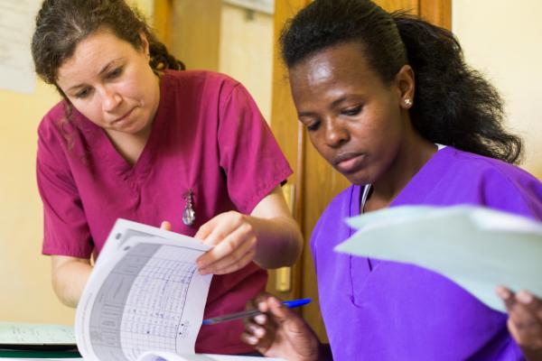 VSO volunteer Miriam and midwife Rahel look through patients' files together