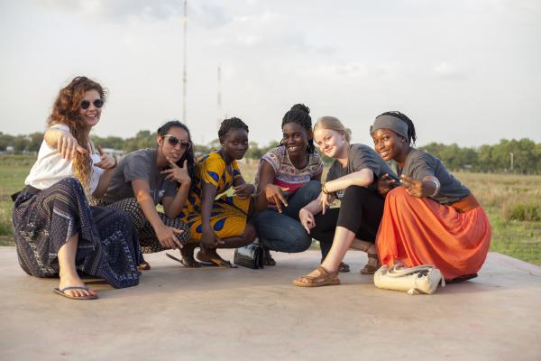 A team of female ICS volunteers crouch down and pose together