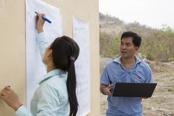 VSO volunteer Giovanni Villafuerte delivering a workshop to around 40 farmers within the Banan co-operative outside their rice warehouse to help them increase their crop yields. The VSO / Accenture IMA4P project, Banan, Cambodia.