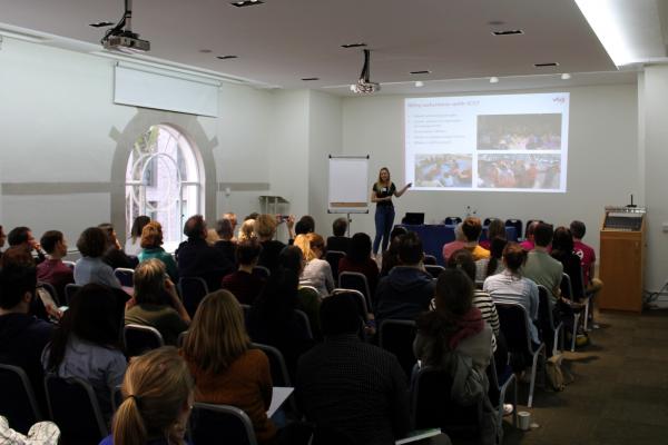 A returned volunteer gives a talk to a crowd