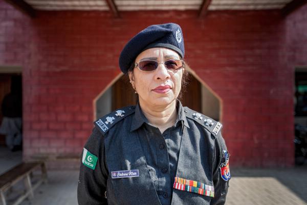 A female police officer stands in full uniform stands outside the police station