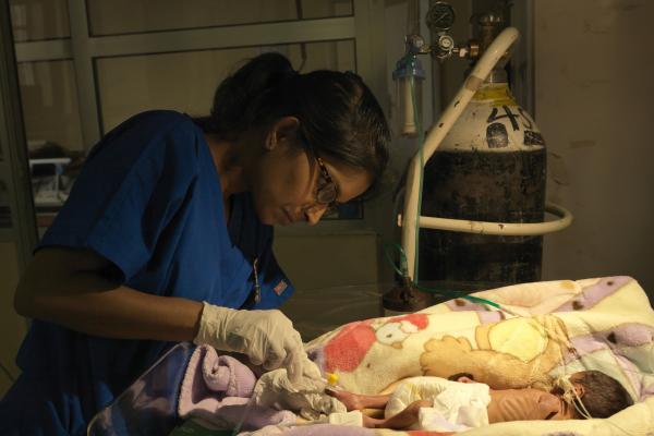 Volunteer midwife Sarika checks on a newborn baby
