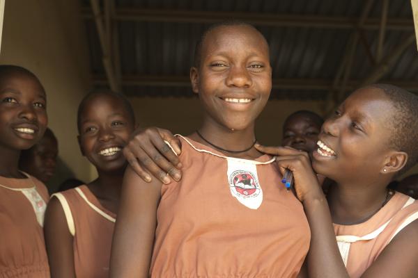 14-year-old Mojo smiles as she stands with her friends at breaktime