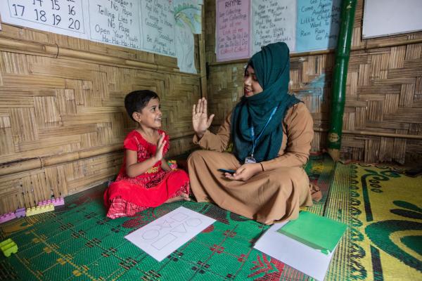 Volunteer in Bangladesh. Volunteer supervisor Muslima Zannat with Mabia, 5, at the ECCE centre, Rohingya Refugee Camp 15 in Jamtoli of Ukhiya