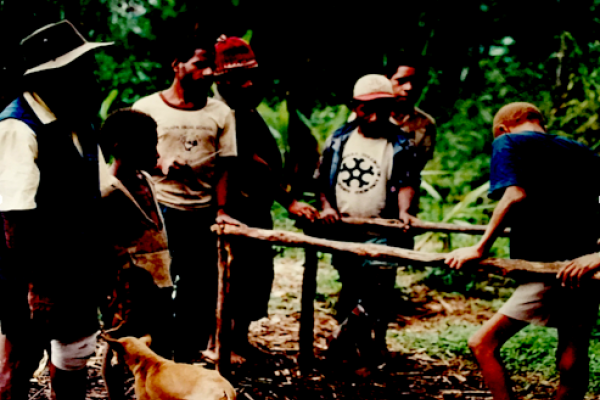 A group of men learn how to make wooden parallel bars to make difficult terrain more accessible for people with disabilities