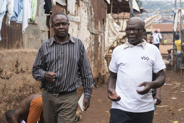 Two VSO volunteers stand side by side in the streets of Sierra leone
