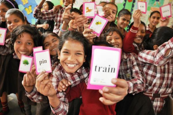Girls excitedly sharing their SMS Story learning cards in a school in Delhi