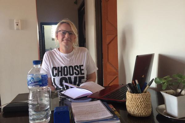 Nicola Whybrow sits at a desk on her laptop, as she works out of her placement accommodation in Nepal.