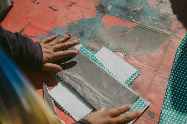 A big sister in Nepal demonstrates how to make reusable sanitary pads.