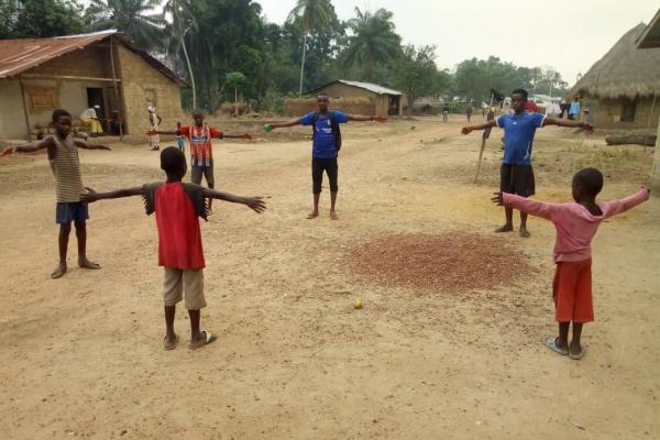 Volunteers teaching a group of children about social distancing