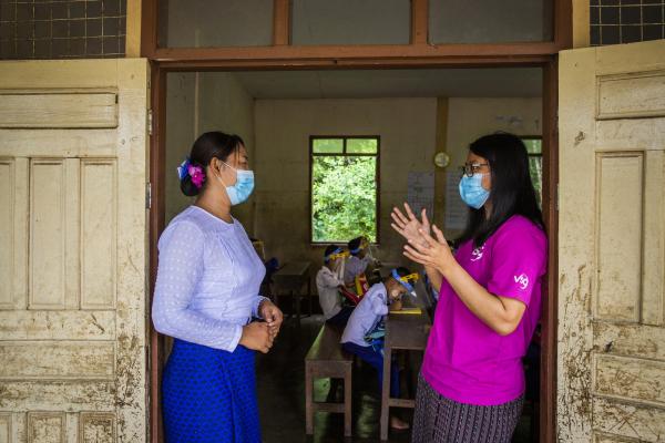 Volunteer and headteacher speak at a school in Mon state, Myanmar