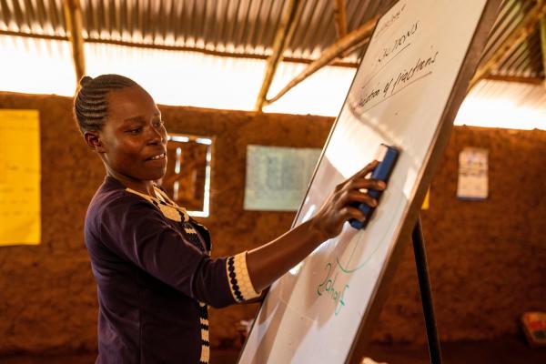 A teacher at the whiteboard in a classroom