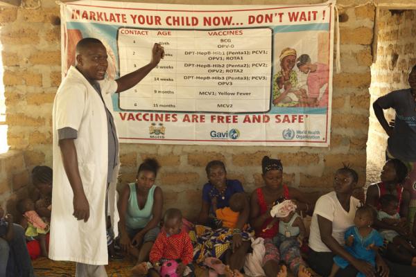Man shares information about vaccines at health outpost in Sierra Leone.