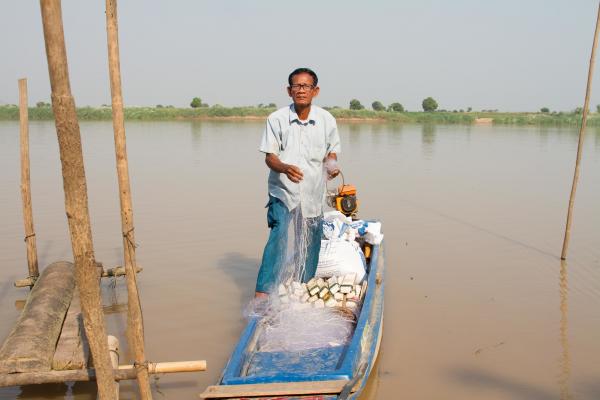 Fisherman-turned-construction worker transports construction materials on the Tonle Sap.