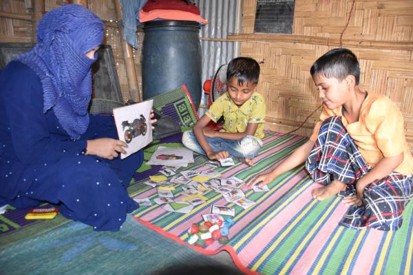 Big Sister Moreom playing a teaching game with two of her young students