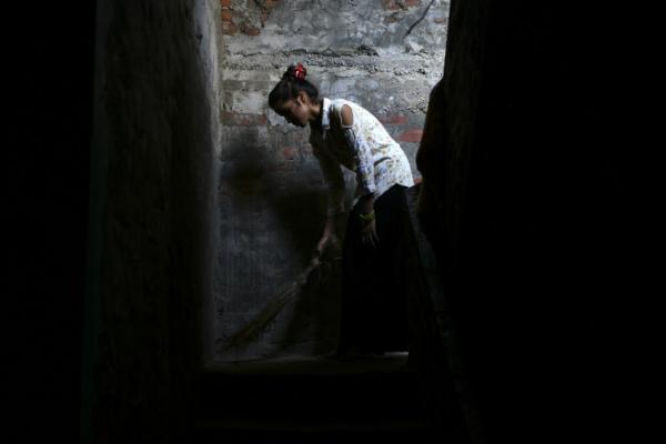 Young girl cleans the staircase at her home in Nepal