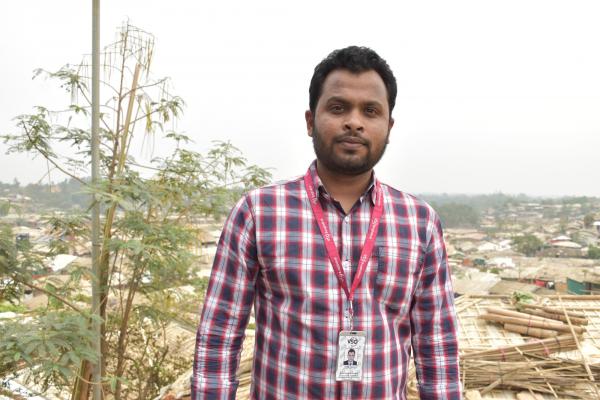 volunteer anup stands in front of camera at Cox's Bazar Refugee settlement 