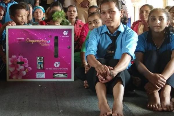 Girls sat around sanitary pad vending machine in Nepal.
