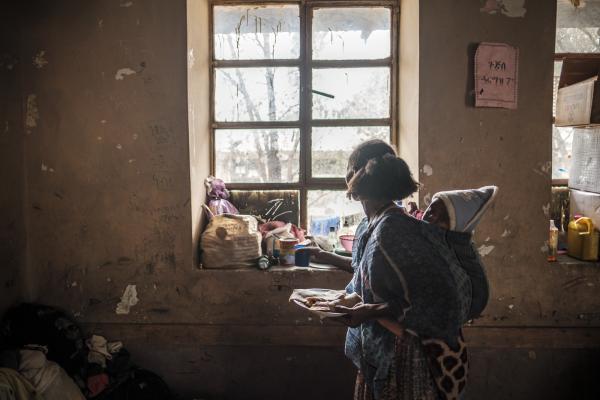 Mother with baby holds a plate of food