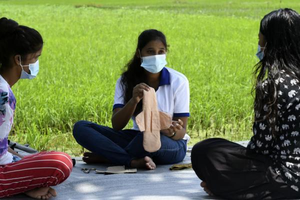 Big Sister Muni Gupta teaching girls to make homemade reusable sanitary pads from old cloth during the lockdown