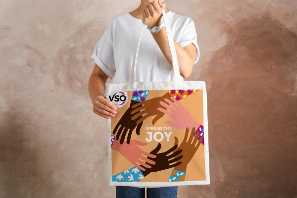 Tote bag reads 'Stronger Together' within a circle of illustrated hands