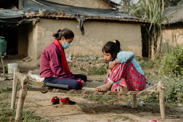 Two adolescent girls study on a bench