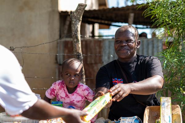 VSO volunteer handing out food package