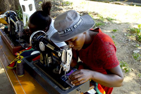 Women using a sewing machine to create clothing to sell