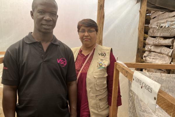 Volunteers stand by the black soldier fly breeding cages