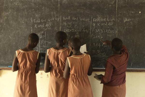 Girls at Moroto Demonstration Primary School learn on a blackboard