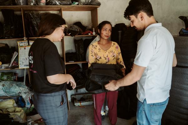 Volunteer Raj and Manisha with Amrita in her bag-making shop.