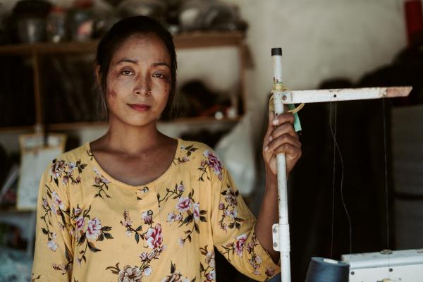 A lady in yellow smiling at the camera.