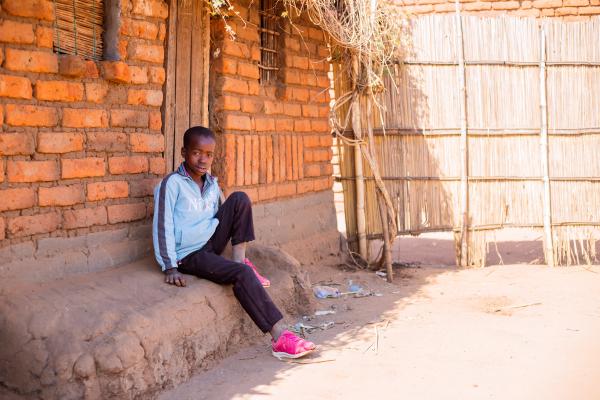 Child in front of home in Malawi.