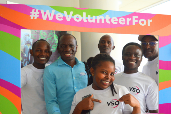 Volunteers pose in a #WeVolunteerFor photo frame