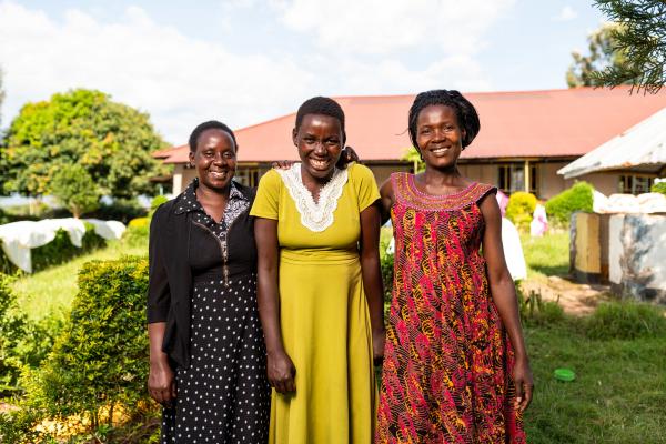 Three women standing in front of a school building.
