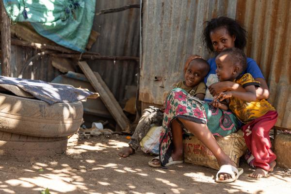 Elizabeth, waste picker, with her two children at her home