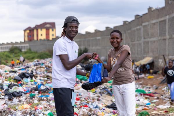 VSO volunteer Lawrence distributing PPE to waste picker Vanessa.