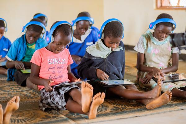 Doreen sitting in the learning centre with an educational tablet