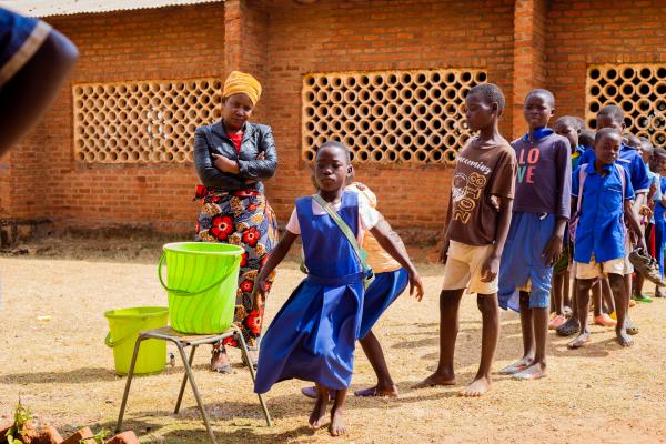 Children line up and wash their hands outside the learning centre