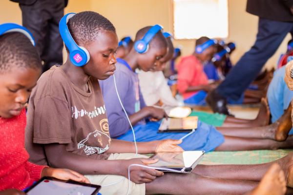 Mphatso sits in the learning centre with an educational tablet